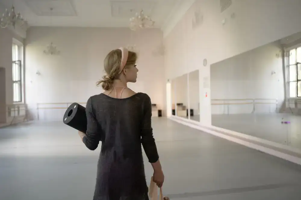 Flamenco student preparing for class in a naturally lit dance studio