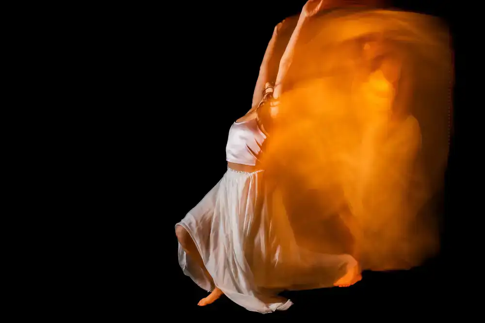 Dancer sweeping the long tail of a bata de cola skirt
